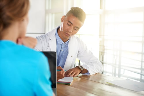 Team of doctor and nurse discussing a patient diagnosis sitting at the desk in bright modern office-1